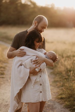 A sequence of intimate family moments captured at sunset in a golden field.