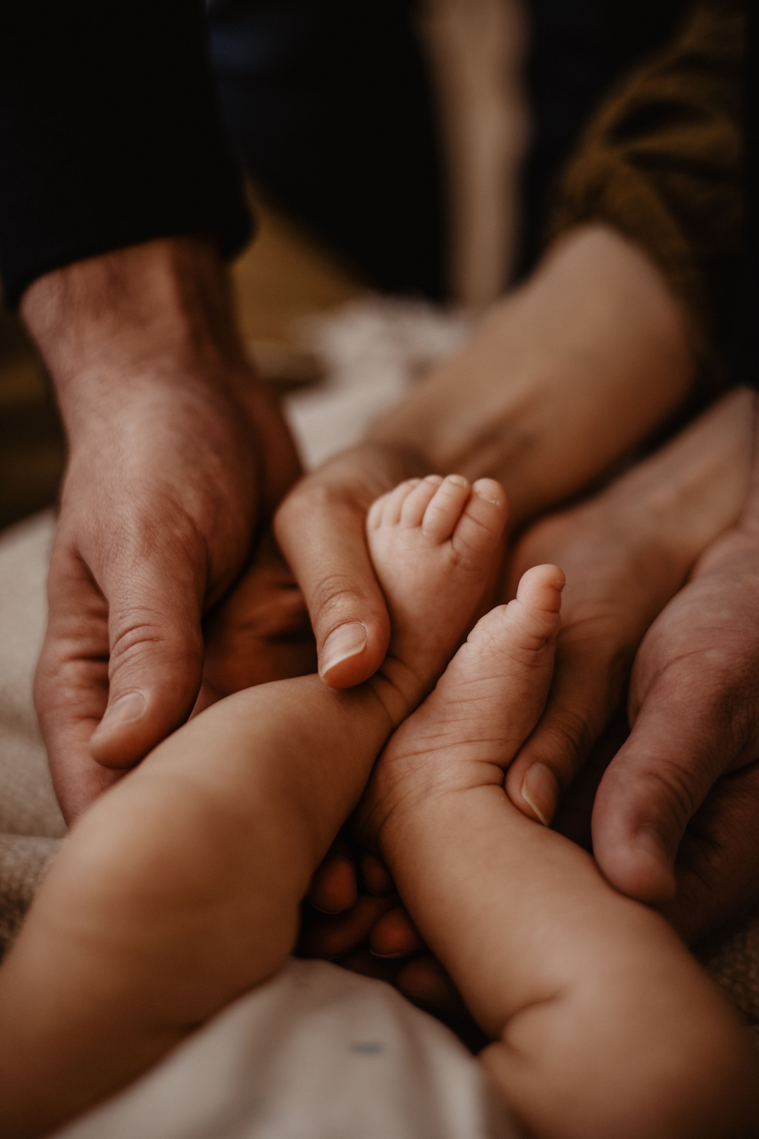 Gentle hands massaging small baby feet in intimate close-up shot.