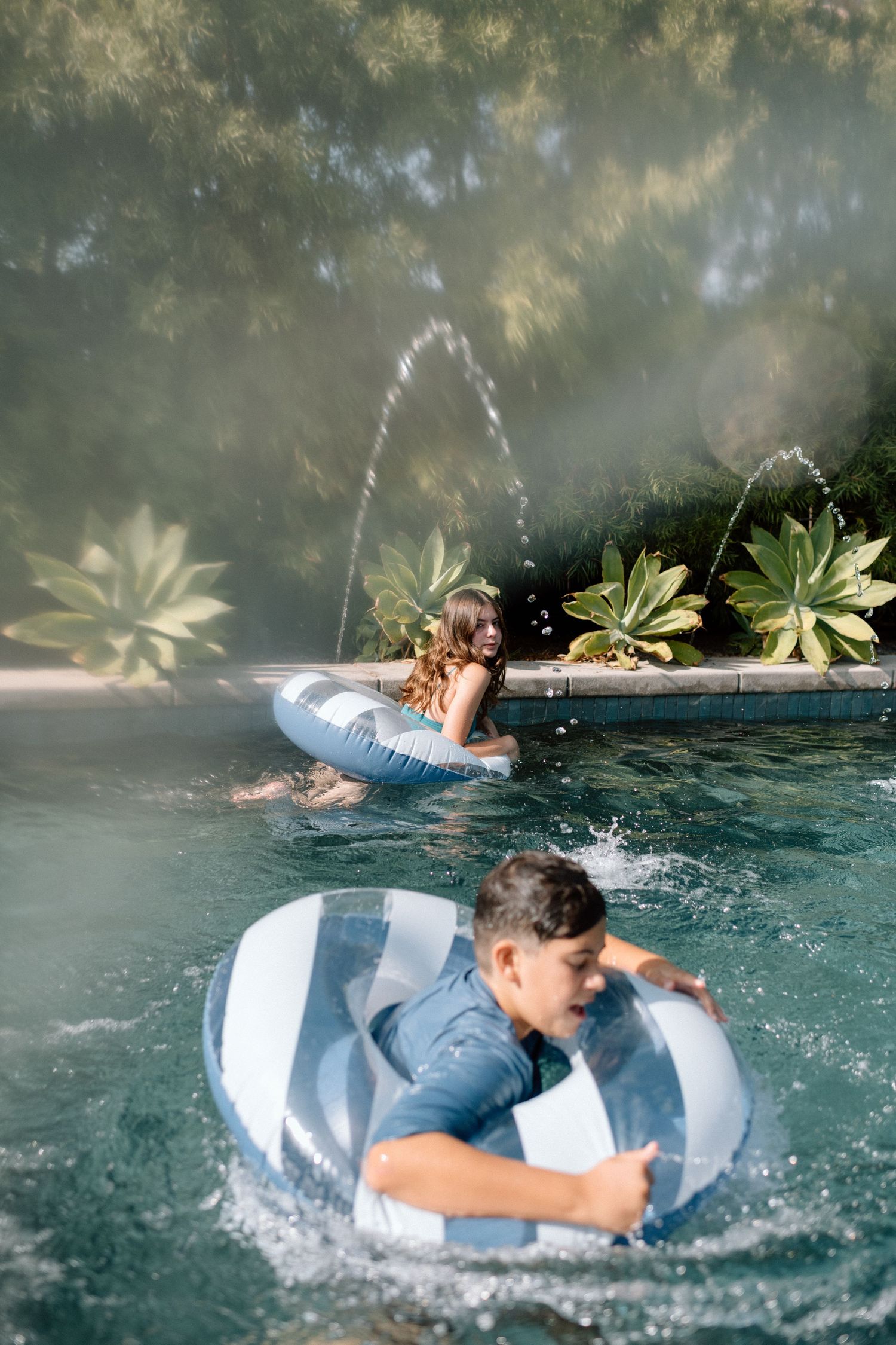 Sequence showing someone falling into a swimming pool while trying to balance on a white float.