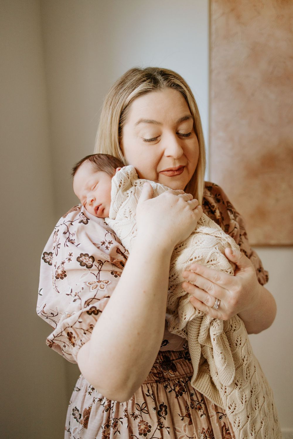 Newborn baby asleep on mother in the comfort of their home in Adelaide with natural light