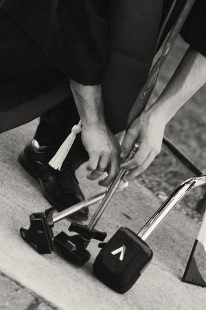 A series of black and white images showing hands reloading a mechanical or musical device in sequential steps.