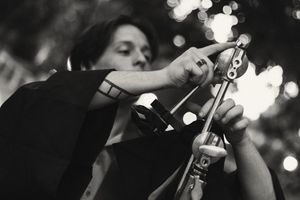 A group of musicians perform on stage with bright stage lighting in black and white photography.