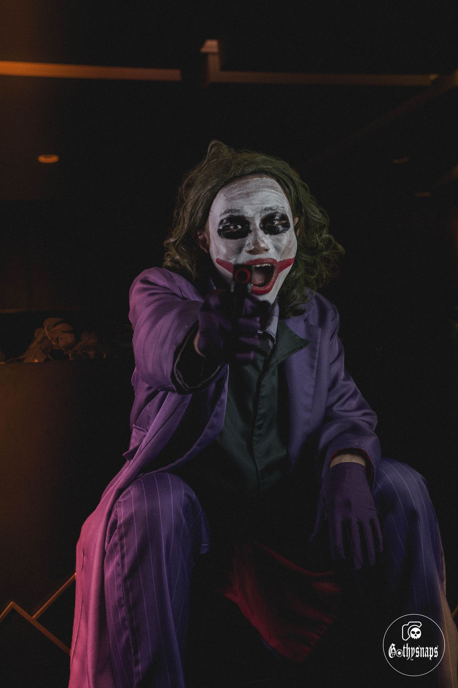 Joker Cosplayer pointing his weapon at the target in front of him.