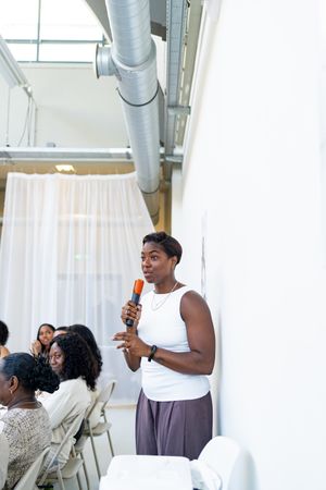 Guests mingling at a social gathering in a bright indoor venue with white curtains.