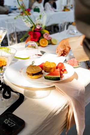 Plates of sandwiches and food served on white tablecloths at an event.