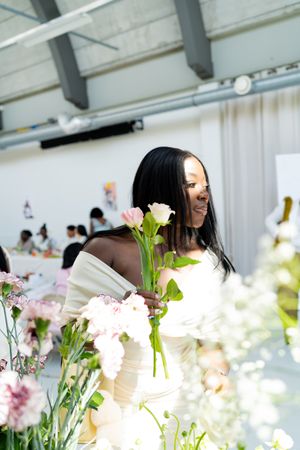 Bright floral arrangements with white and pink flowers decorate a sunny indoor space.