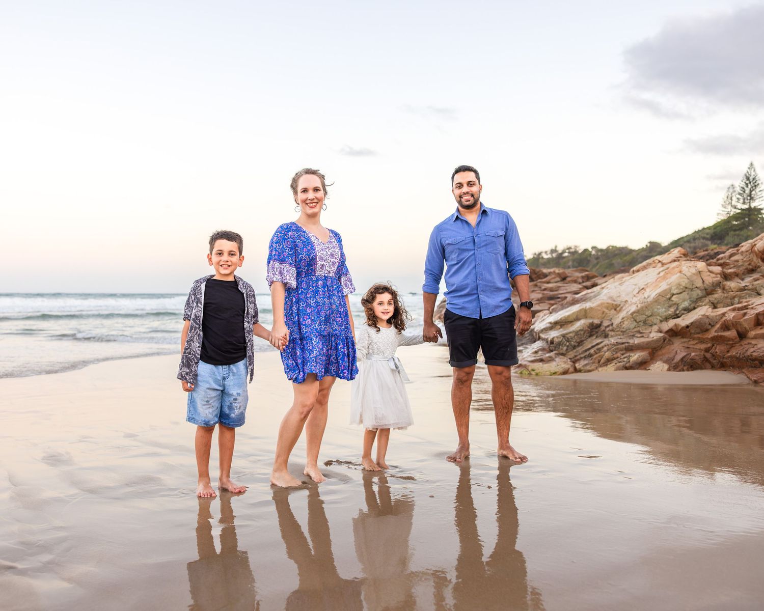 Family standing together on a Sunshine Coast Beach getting family photo memories.