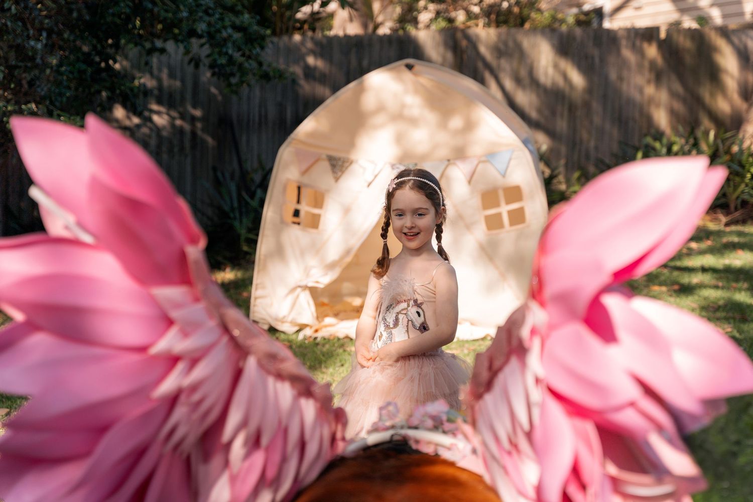 A girl surprisingly looking at a unicorn during a birthday photoshoot in Lane Cove Sydney