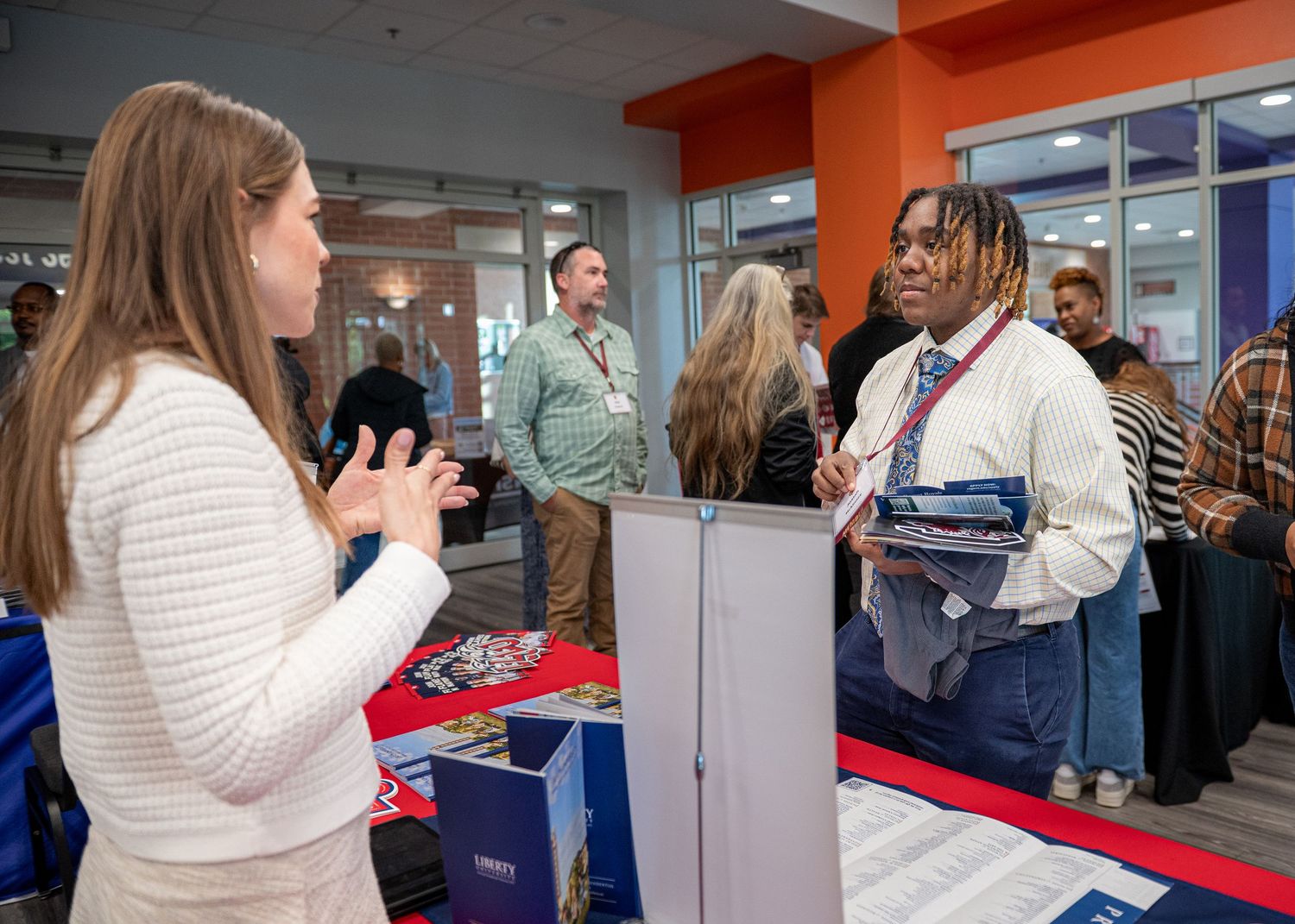 People checking in at registration tables during business conference.