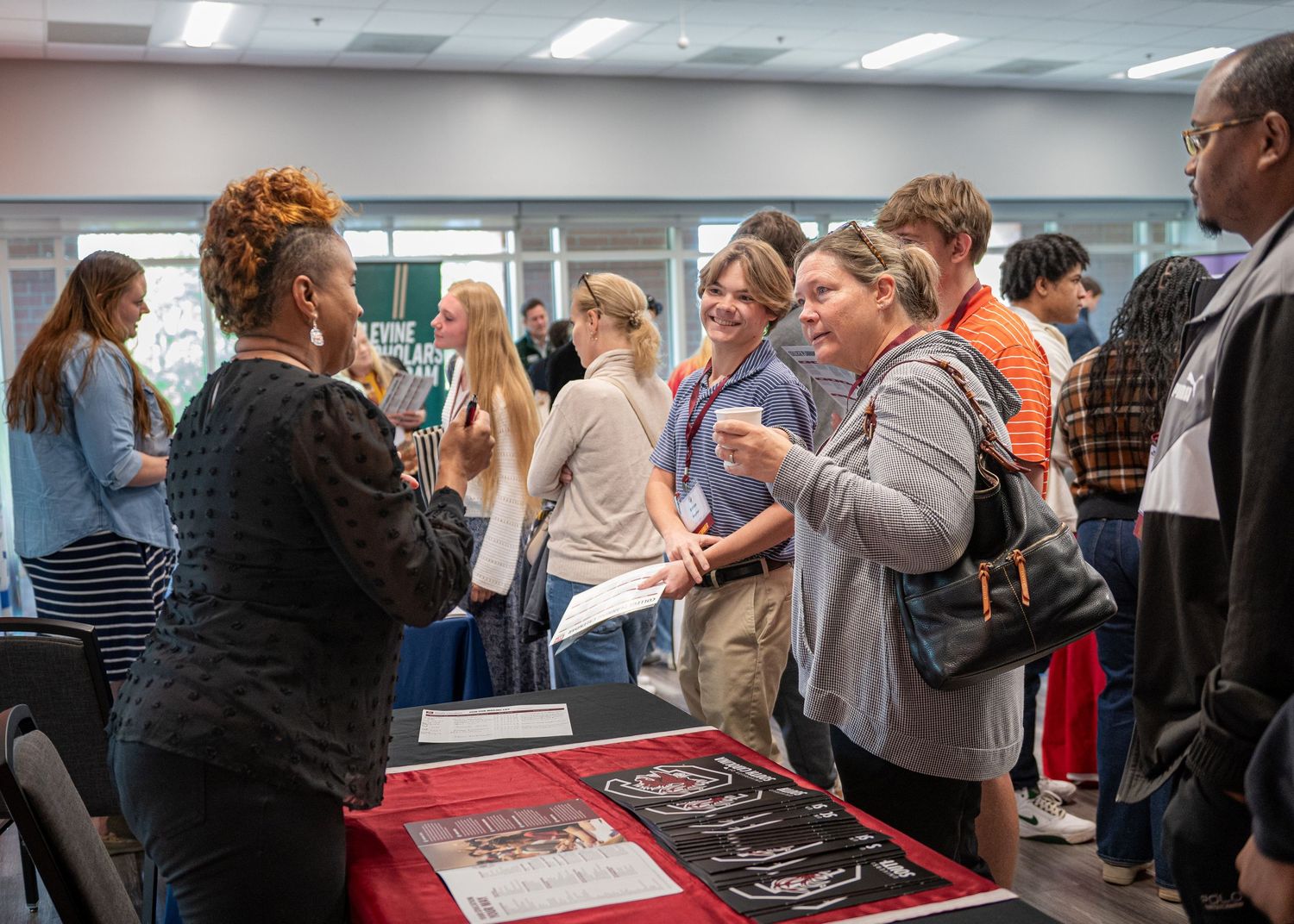 Attendees gathering around registration tables at professional event.