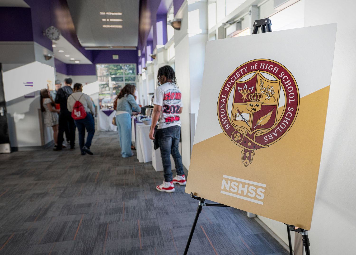 College resource fair booth setup with university banners and information materials displayed on tables.