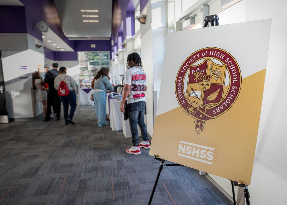 College resource fair booth setup with university banners and information materials displayed on tables.