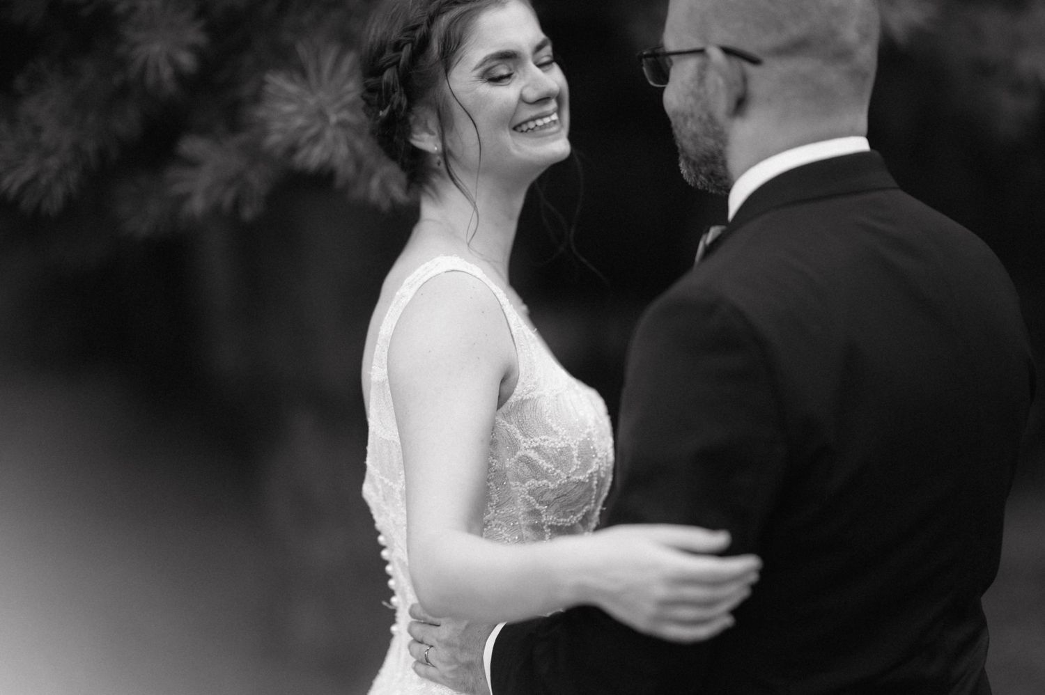 Black and white wedding portraits showing joyful intimate moments between a couple in formal attire.