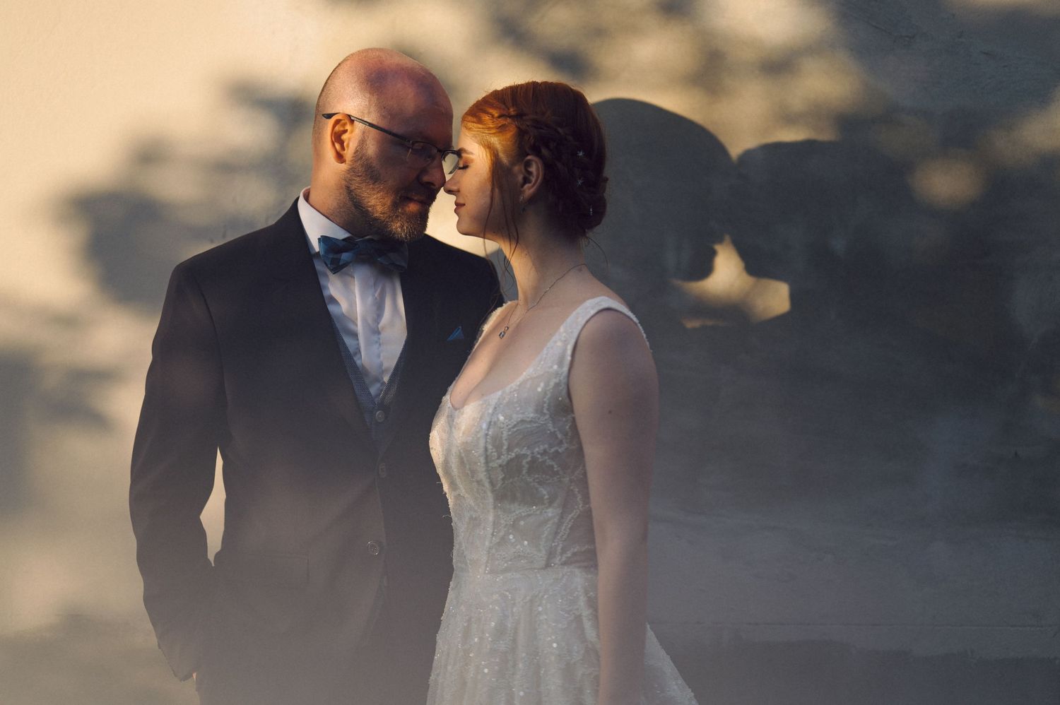 A romantic wedding couple gazes at each other in soft evening light with ethereal fog surrounding them.