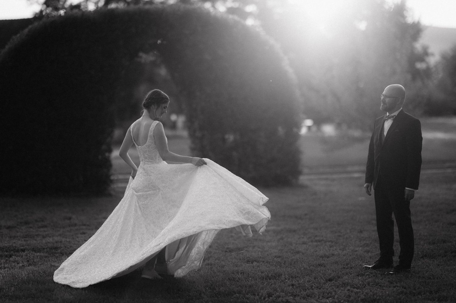 A black and white wedding photo sequence showing the bride's dress billowing gracefully in the wind.