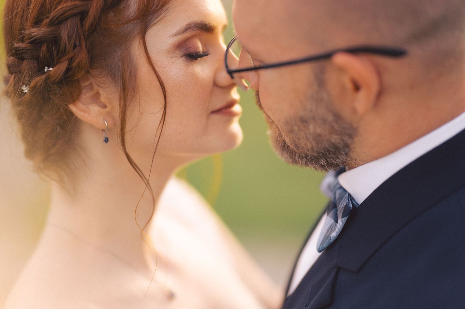 Close up of a romantic wedding couple in an intimate moment outdoors with soft natural lighting.