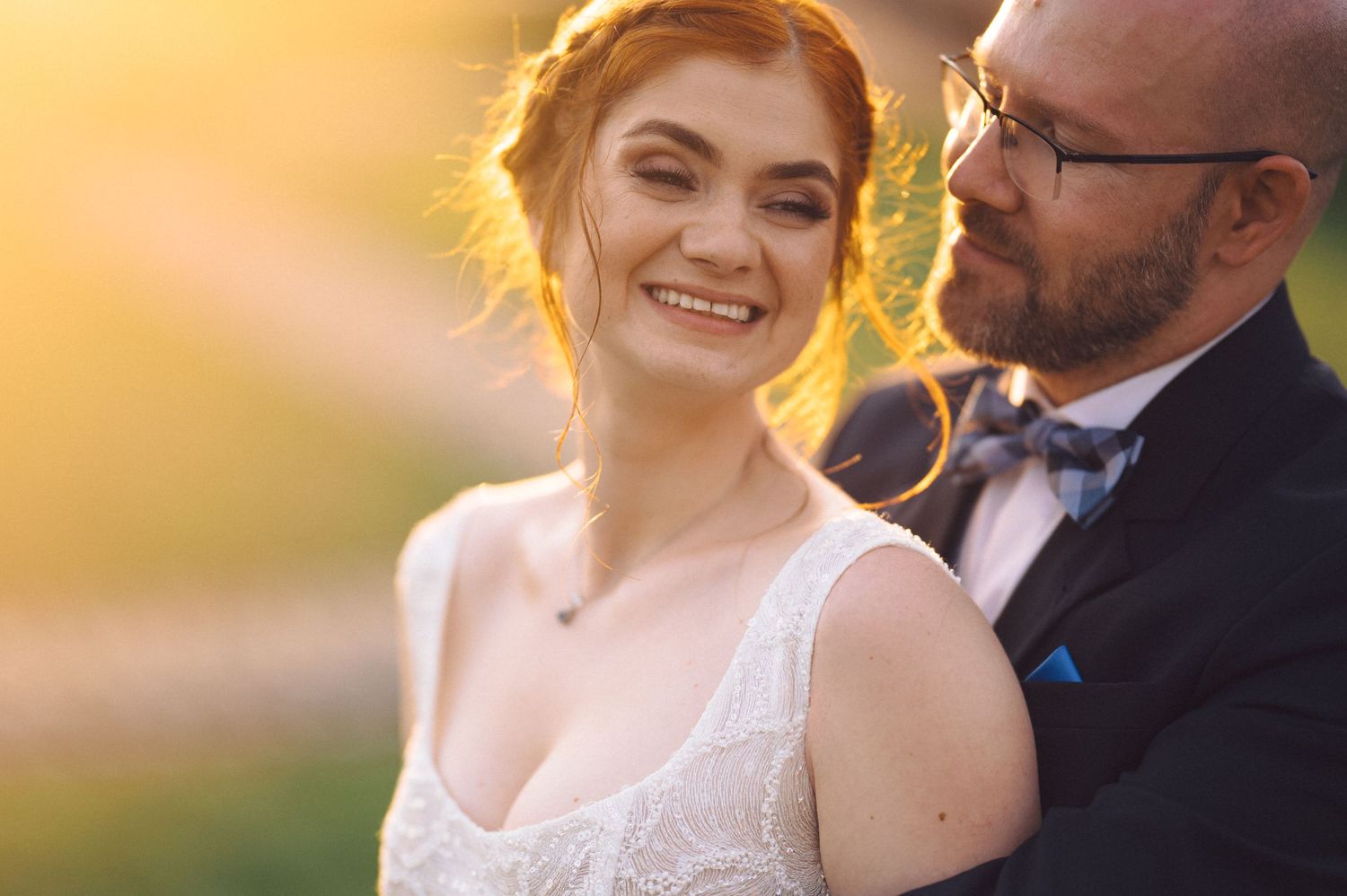 Wedding portrait captured during golden hour showing tender romantic moment between newlyweds.