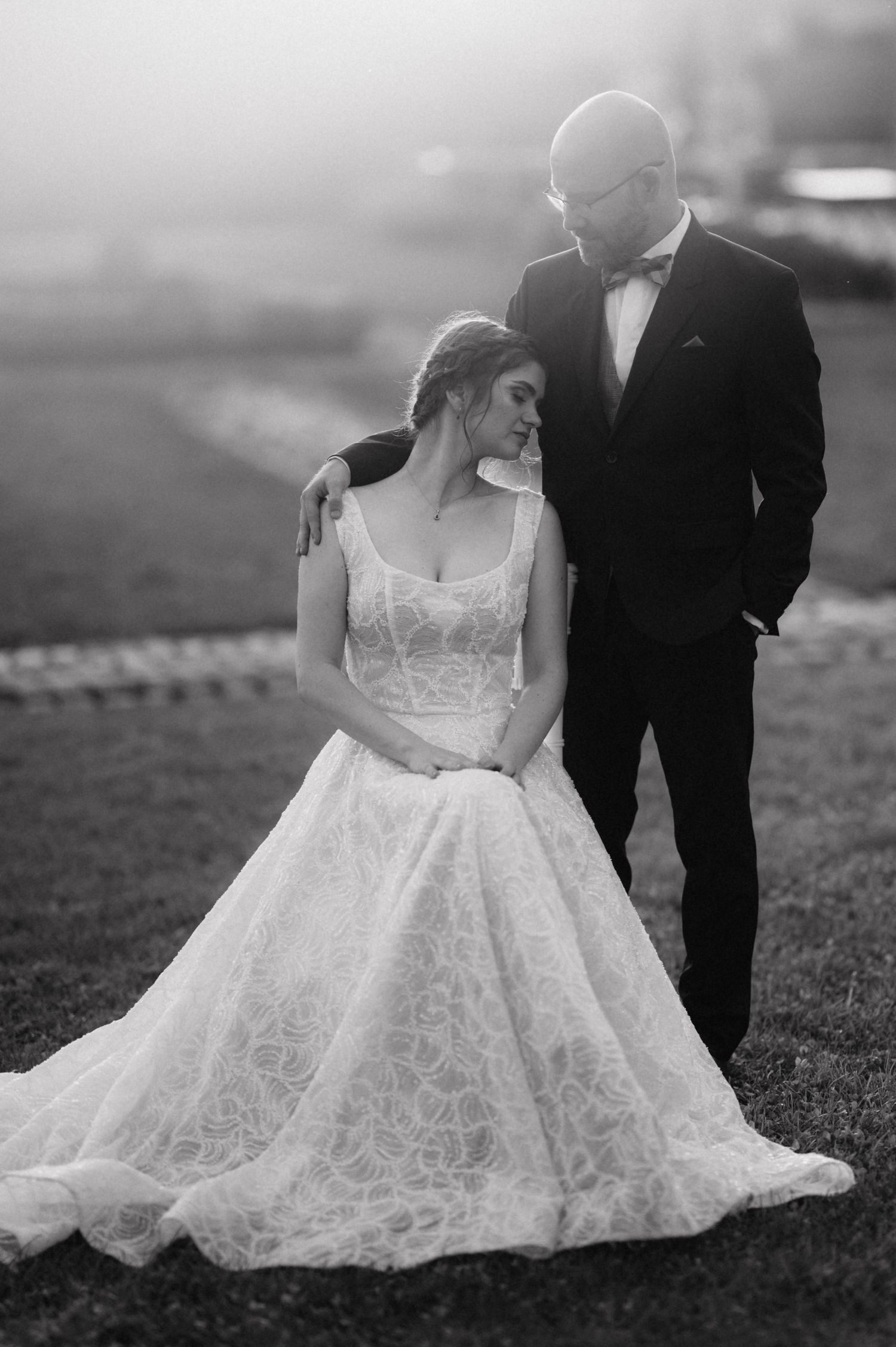 Elegant black and white wedding portrait showing tender moment between newlyweds.