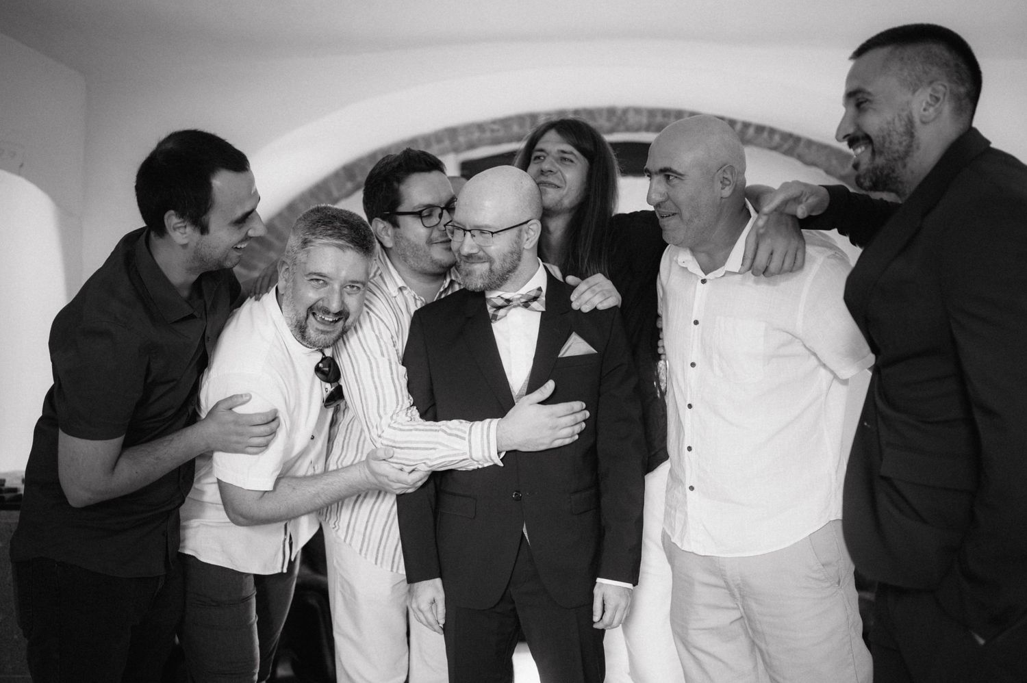 Black and white photo collage showing emotional reactions and candid moments between people at what appears to be a wedding reception.