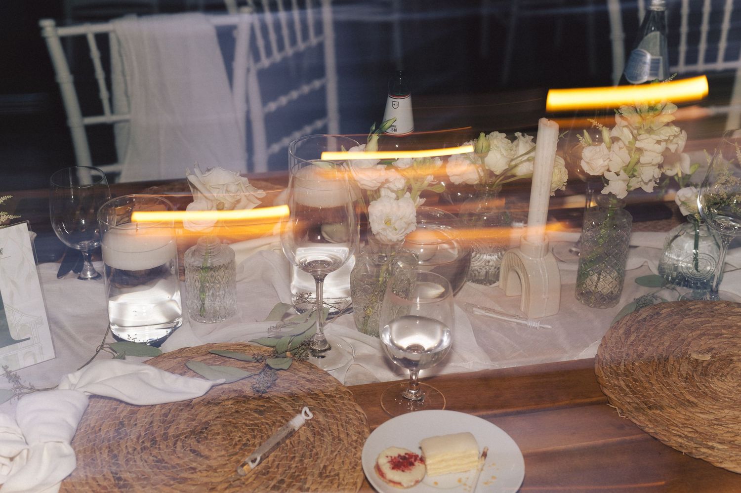 Elegant table setting with rustic woven placemats and glowing candles on a decorated dining table for an evening event.