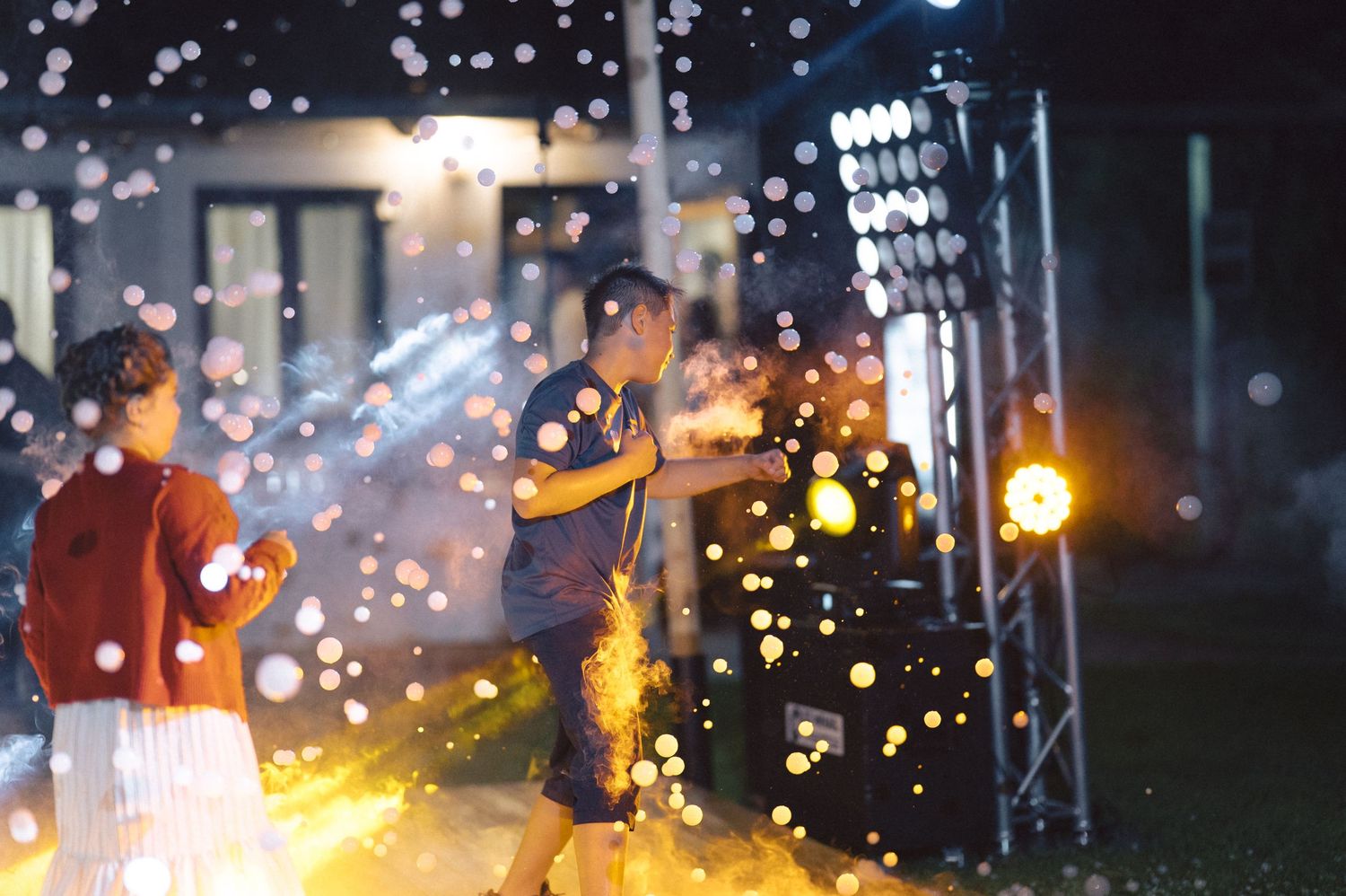 Musicians perform on stage at night with sparkling lights and bokeh effects creating a magical atmosphere.