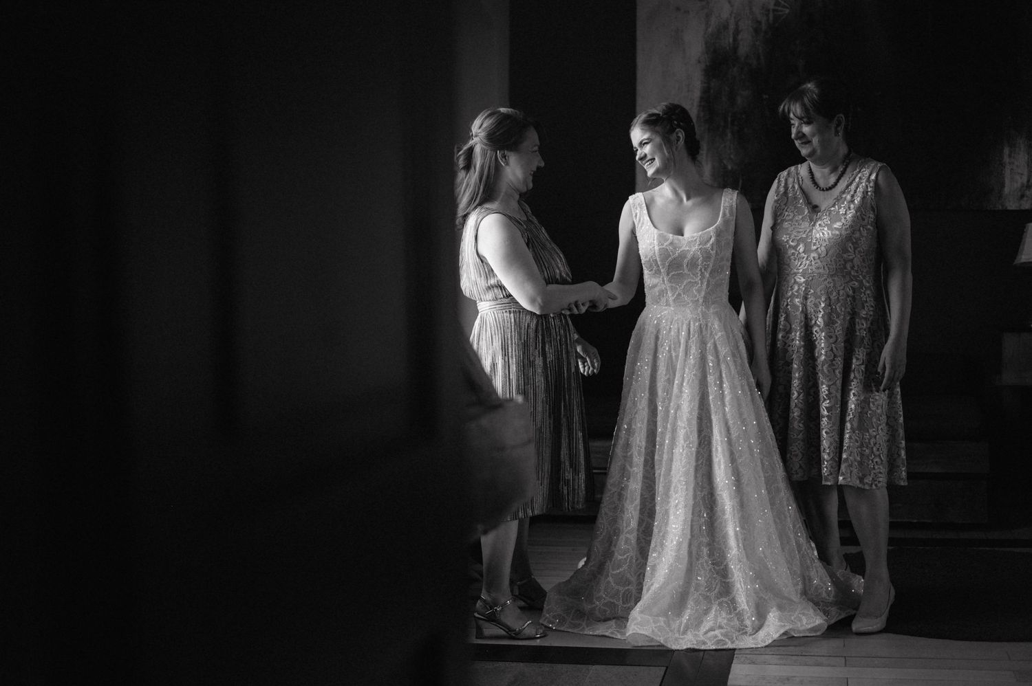 Dark black and white photo series showing vintage-style wedding preparation scenes with flowing white dresses.