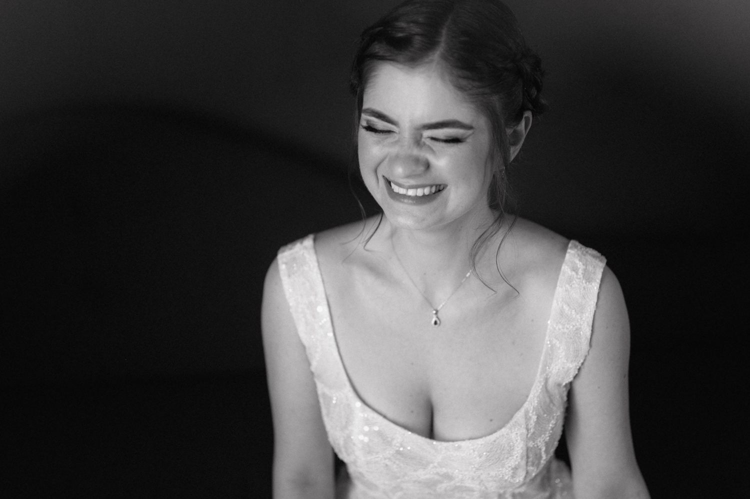 A series of black and white photos showing close-up details of a bride in an elegant white wedding gown.