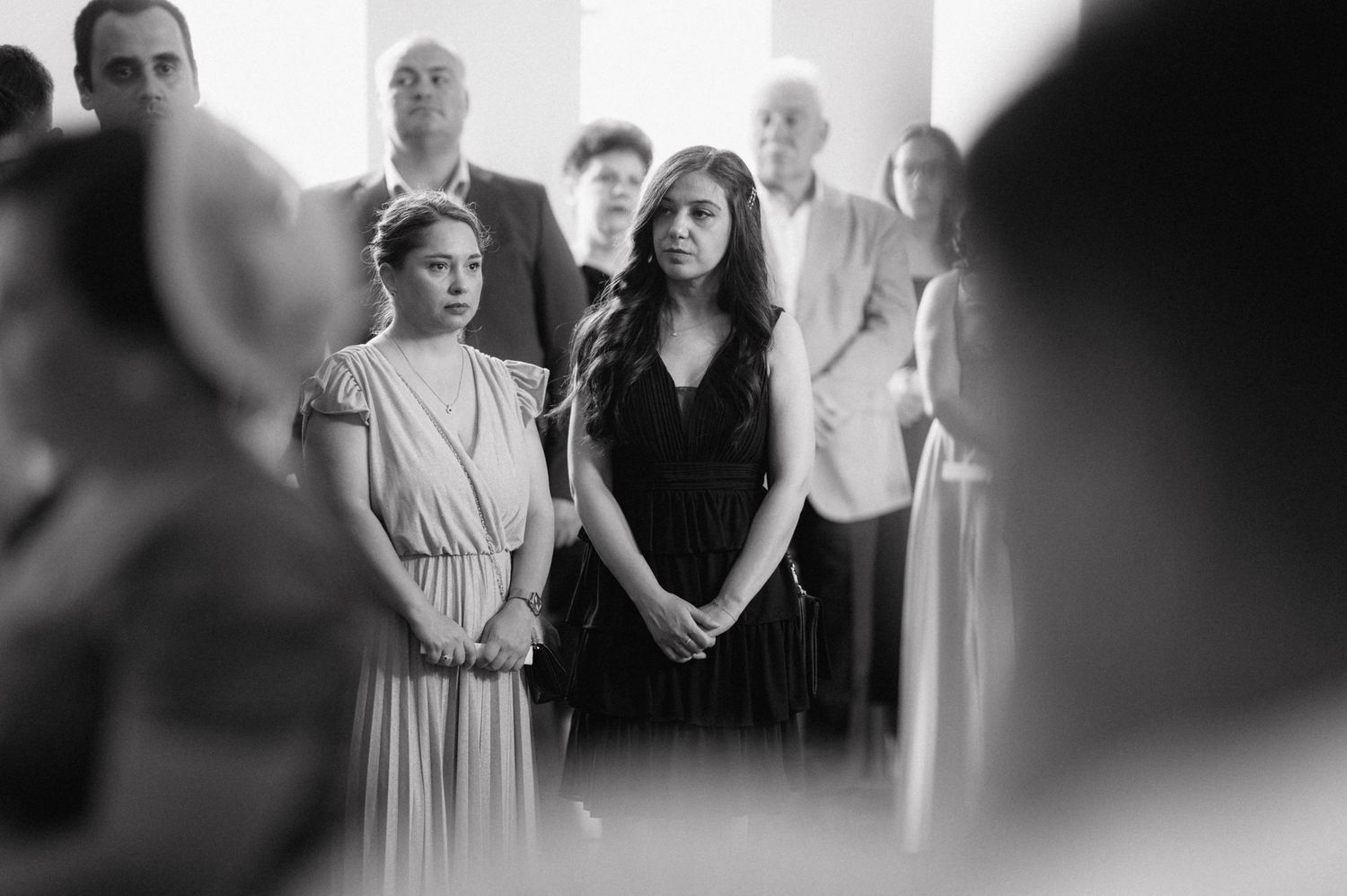 A black and white photo showing a small group of people gathered closely together during what appears to be a ceremony.