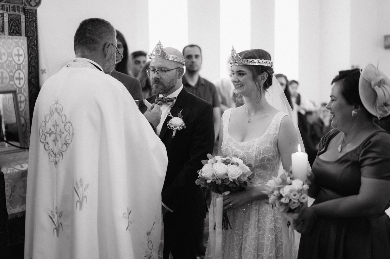 A series of black and white wedding ceremony moments showing guests and couples celebrating in a church setting.