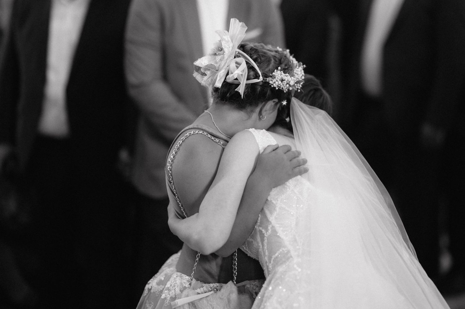 A black and white portrait of an elegant couple embracing at their wedding celebration.