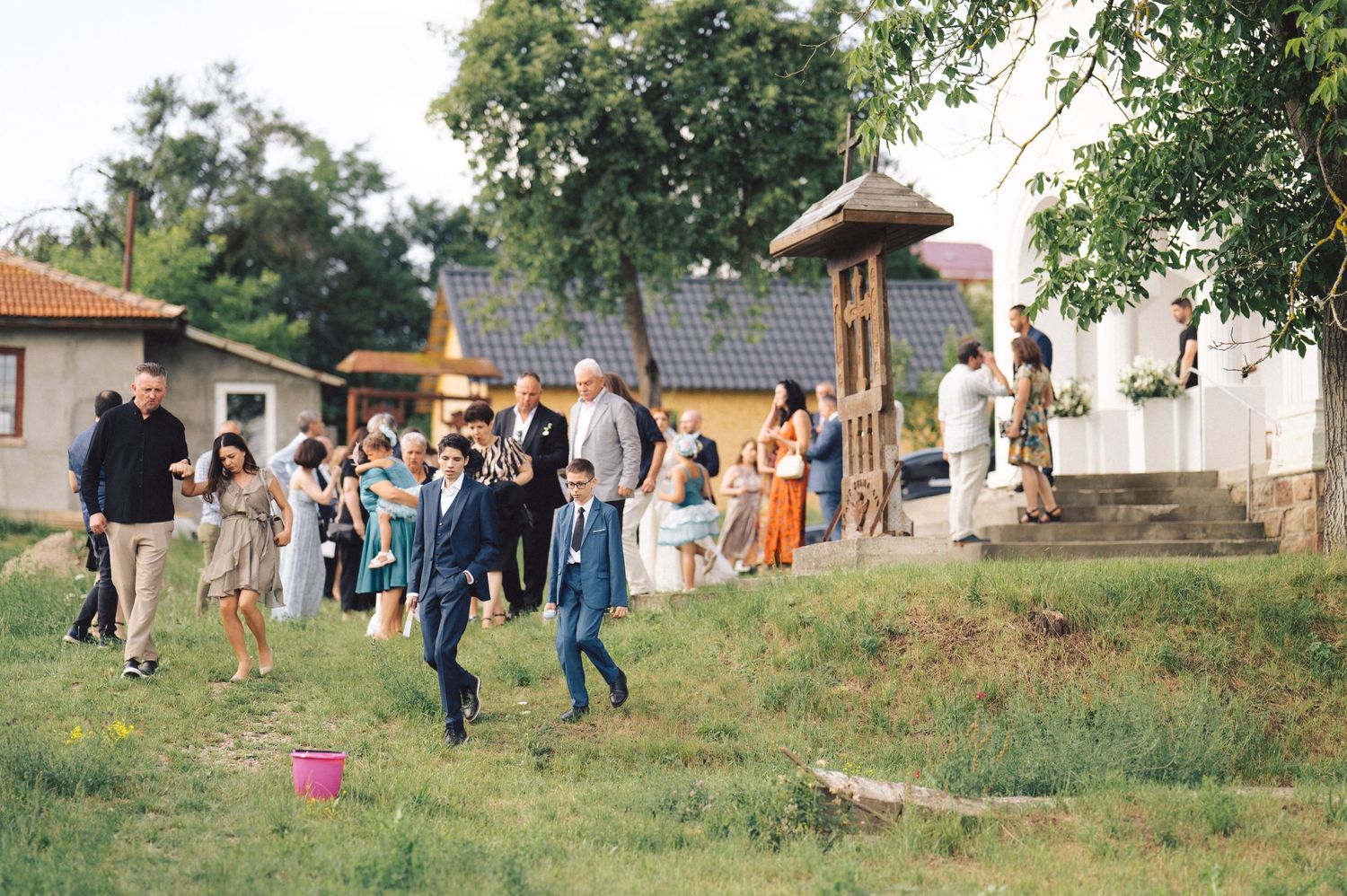 People walking up a grassy hill at an outdoor community gathering event.