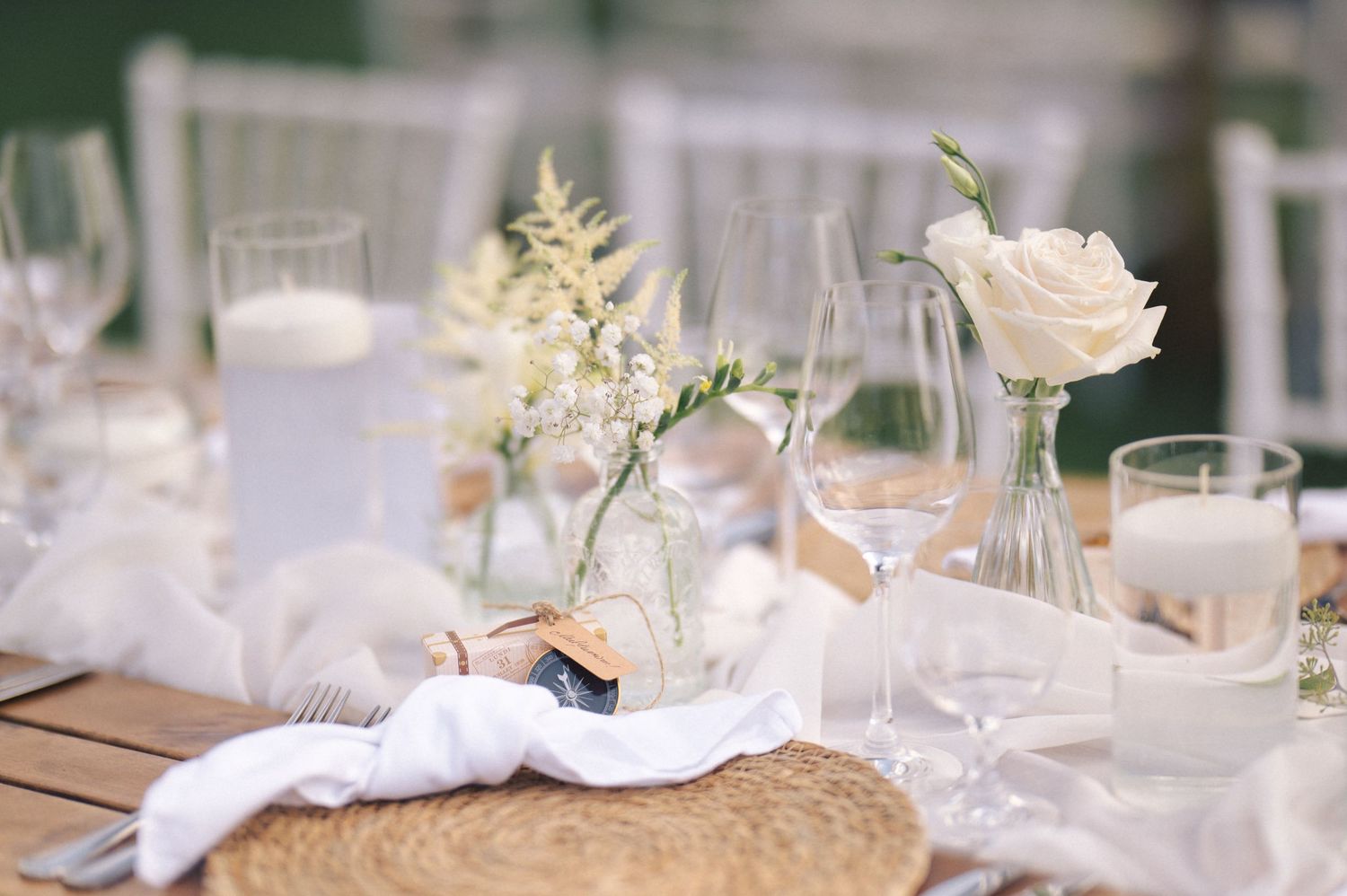 Elegant white and gold table settings with floral centerpieces and crystal glassware at a formal reception.