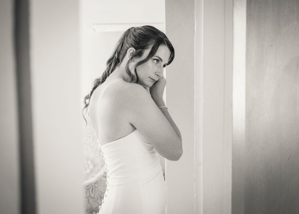 Black and white portrait of someone in a wedding dress looking over their shoulder.