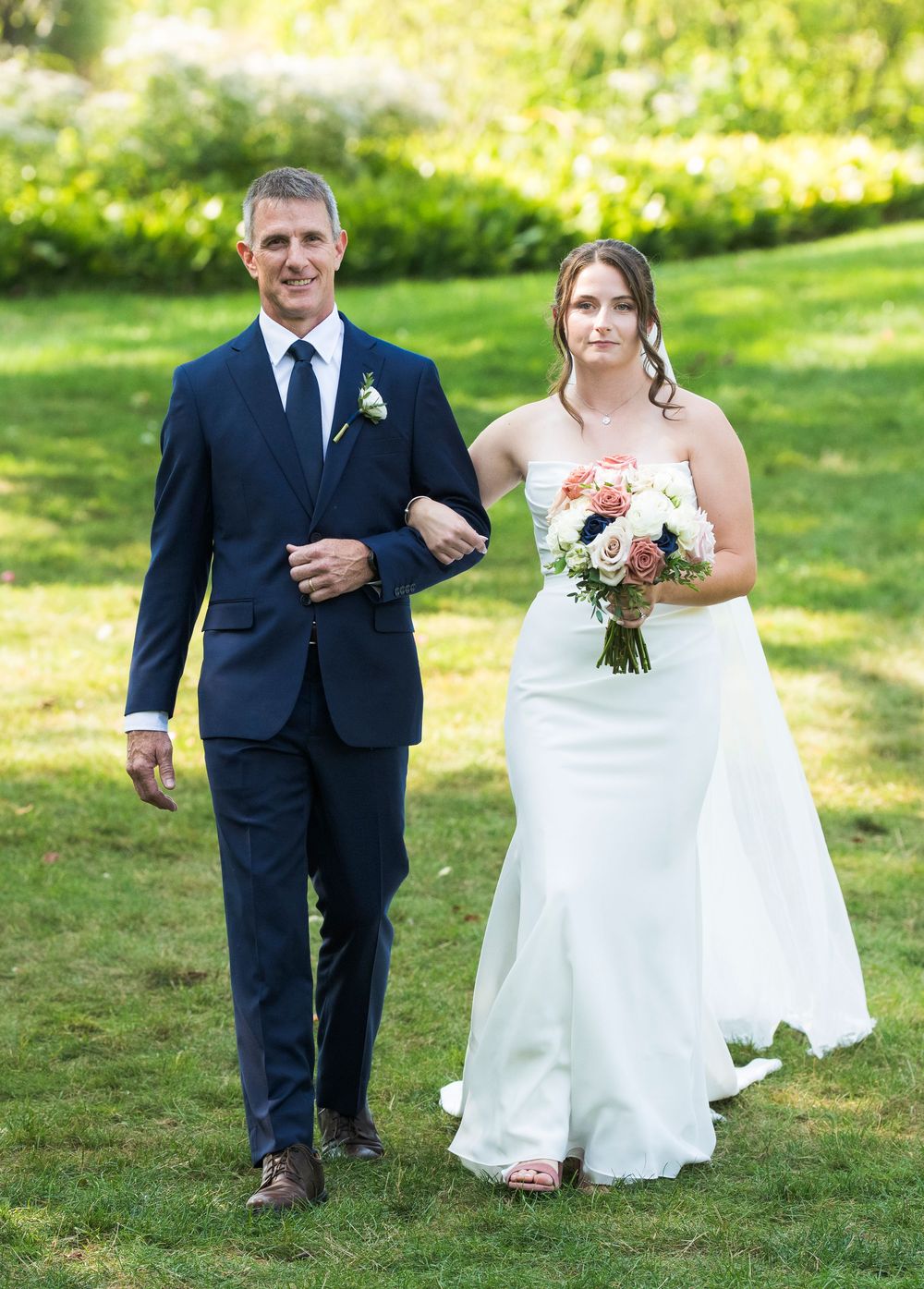 Wedding couple takes outdoor portraits in a lush green garden setting.