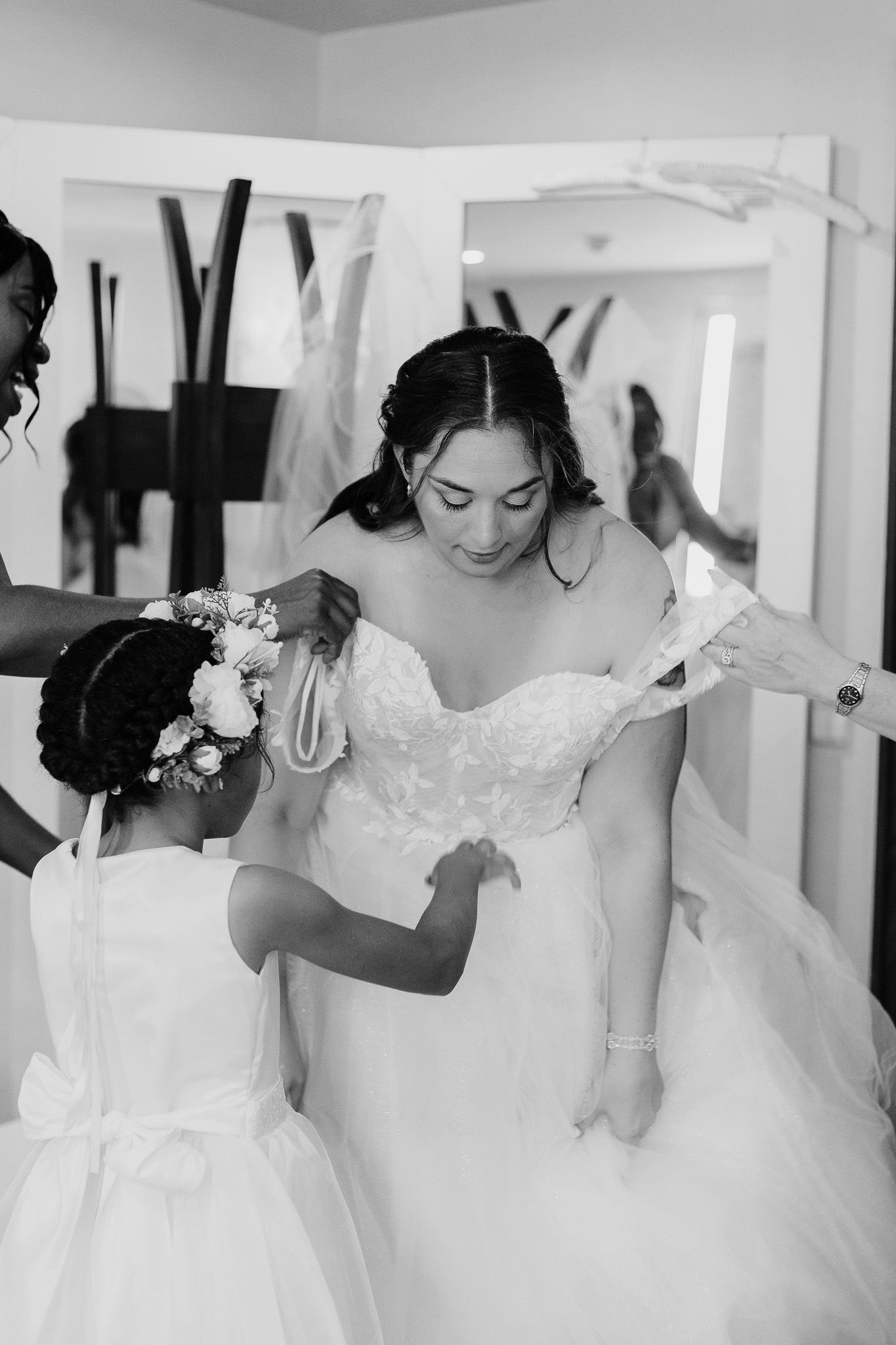 Four elegant white wedding dresses on display in a bridal boutique with delicate lace and beaded details.