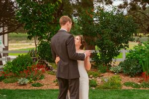 Couple sharing romantic moment in garden setting during outdoor celebration.