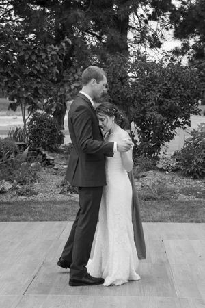 Black and white sequence shows couple sharing first dance on outdoor wooden deck during wedding reception.