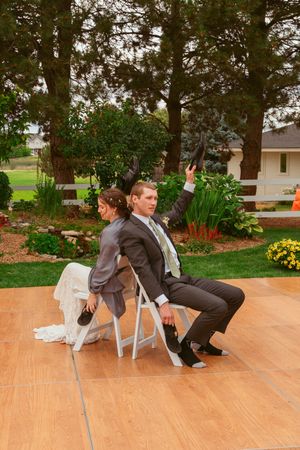 Wedding dancers performing a choreographed sequence on an outdoor wooden dance floor.