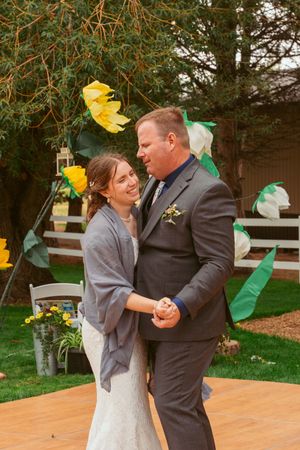 Wedding couple dances together on an outdoor terrace decorated with yellow and green streamers.