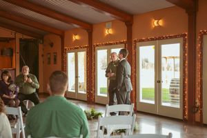 A panoramic view of a rustic wooden event venue interior with exposed beams and warm lighting.