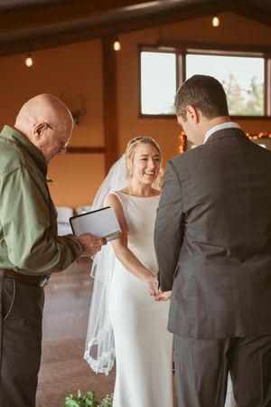 A series of intimate wedding ceremony moments showing a couple and officiant in a warmly lit indoor venue.