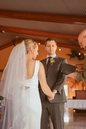An intimate wedding ceremony moment with the bride in a flowing white dress and veil.