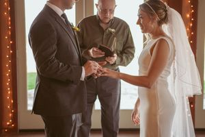 Wedding ceremony candid shots showing emotional exchange of vows in front of string lights.