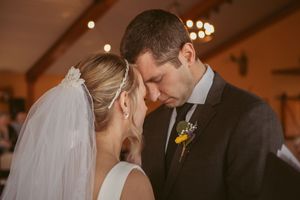 An intimate moment between newlyweds during their wedding ceremony with soft lighting.