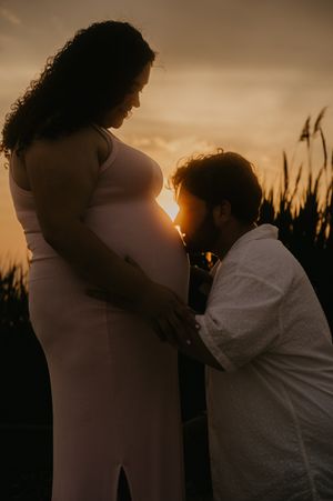 Silhouettes against golden sunset show tender family moments by tall reeds in Old Saybrook, Connecticut.