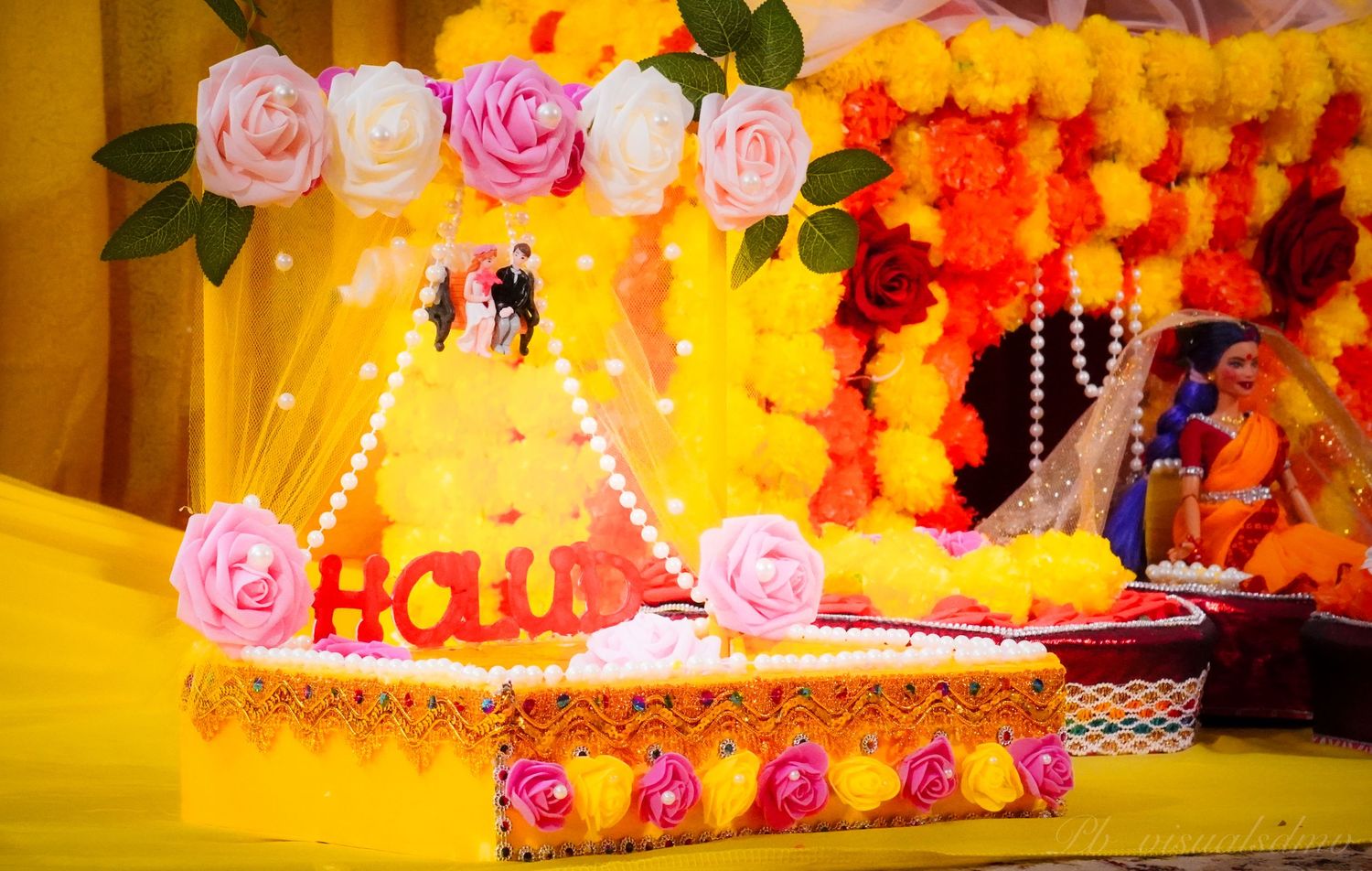 Bright and Vibrant event setup with traditional desi event decor, dolls, floral elements during a Gaye Holud or Tumeric Night
