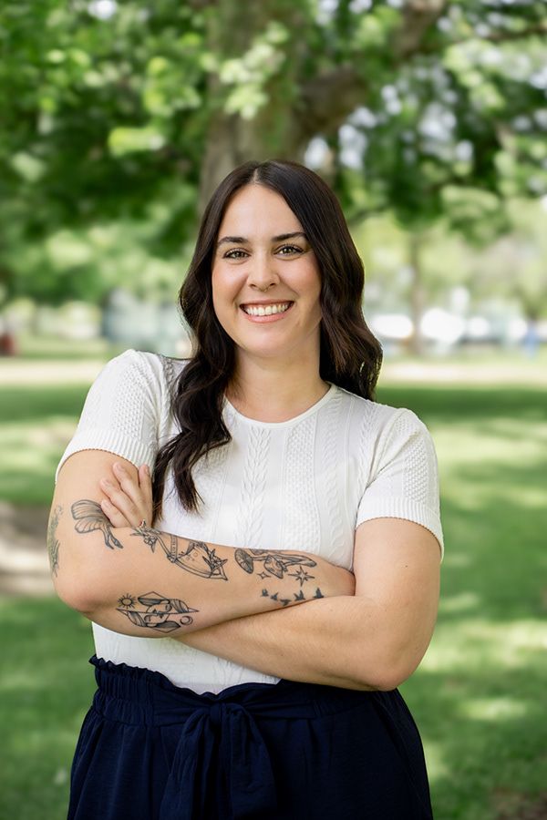 Professional outdoor headshot of woman smiling confidently in natural light
