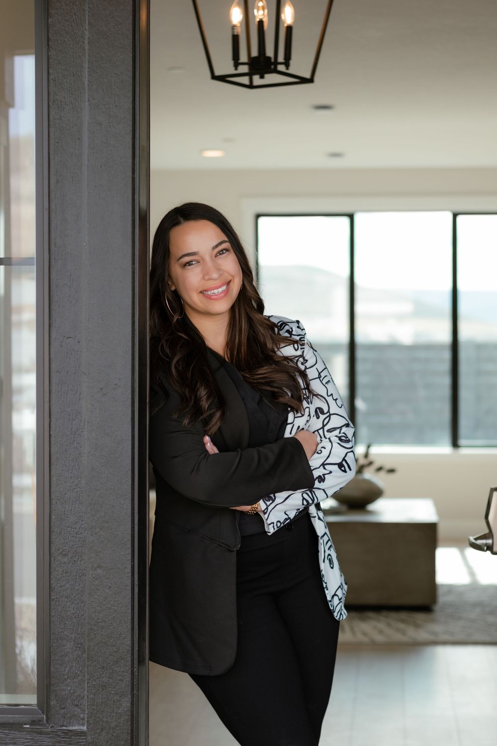 Branding headshot of female realtor in leaning against a door frame smiling confidently in Kennewick WA home