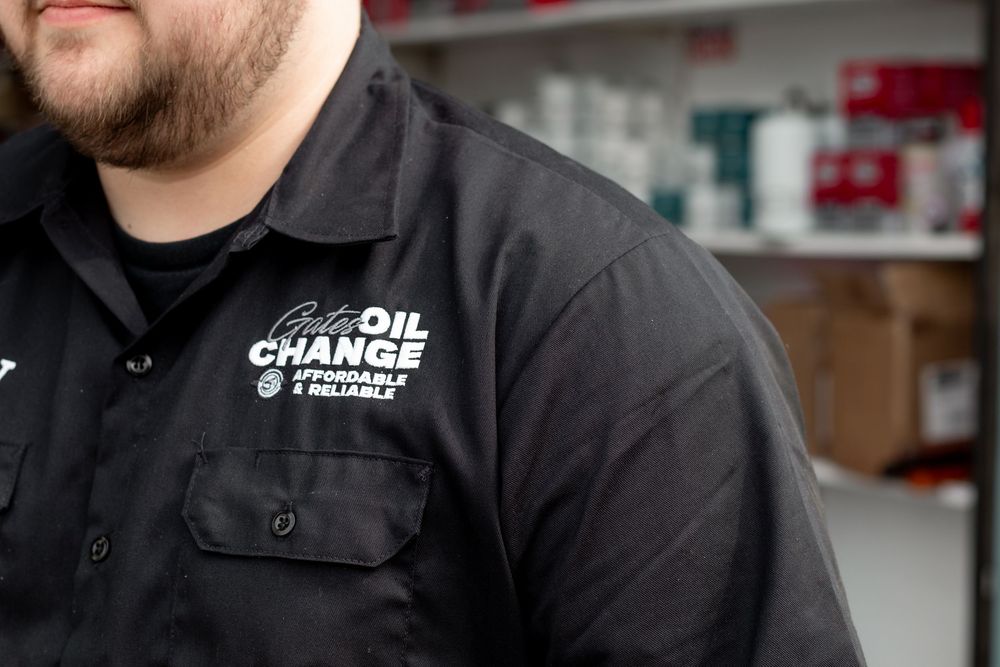 Professional detail shot of technician wearing Quick Oil Change shirt during workplace branding session