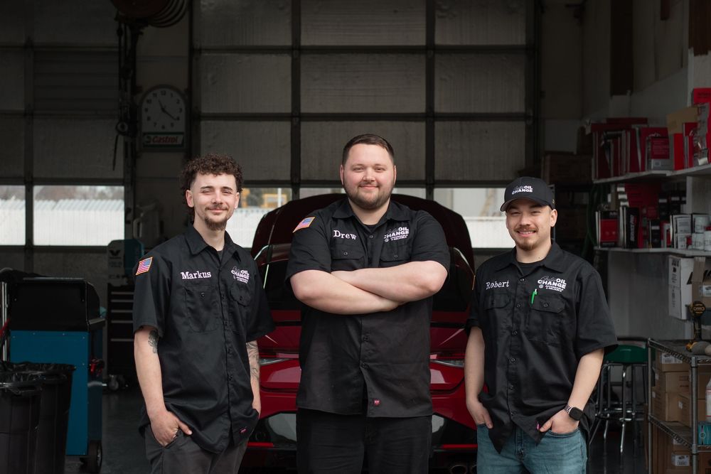 Team photo of oil change technicians standing in front of garage bays during branding session at Gates Oil Change in West Richland WA